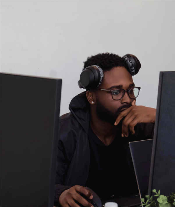 Man with glasses and headphones looking at computer