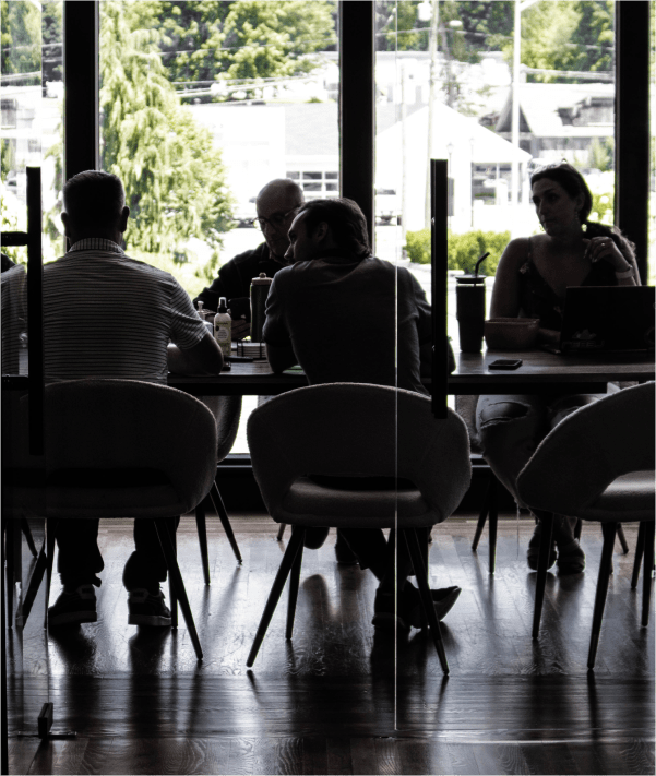 Group of people sitting around a desk in a conference room