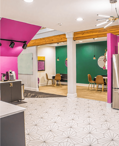 An office bistro space with white tile floor and pink walls